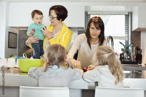 Photo: Girls with her mother and grandmother in a kitchen Girls with her mother and grandmother in a kitchen
