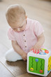 Baby girl playing with a musical block toy