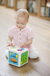 Baby girl playing with a musical block toy