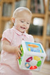 Baby girl playing with a musical block toy