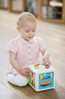 Baby girl playing with a musical block toy