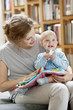 Woman reading a story to her baby from a picture book