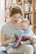 Woman showing a picture book to her daughter
