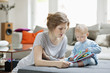 Woman showing a picture book to her daughter
