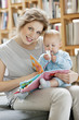 Woman showing a picture book to her daughter