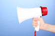 red and white megaphone in hand on blue background