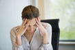 Close-up of a businesswoman suffering from a headache in an office