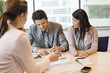 Couple signing documents with business executive