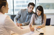Couple signing documents with business executive