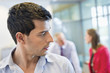 Male executive listening to his colleagues conversation in an office