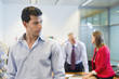 Male executive listening to his colleagues conversation in an office