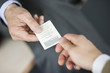 Close-up of Businessman giving card to another businessman