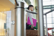 Businesswoman talking on a mobile and holding files and bag in an office