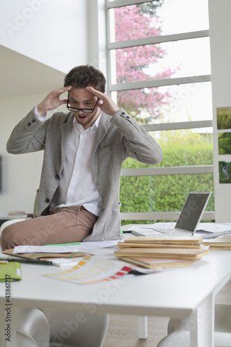 Photo: Interior designer looking surprised in the office Interior designer looking surprised in the office