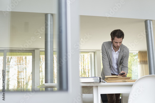 Photo: Interior designer using a mobile phone in the office Interior designer using a mobile phone in the office