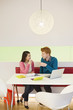 Business couple holding soft drinks and discussing in an office