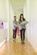 Fashion designers carrying clothes and walking in a corridor