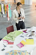 Female fashion designer text messaging in an office