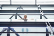 Foto: Low angle view of a woman looking from the balcony of an office building Low angle view of a woman looking from the balcony of an office building