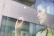 Businesswoman drawing a house on a glass surface