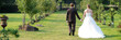 brautpaar schlendert hand in hand durch einen park