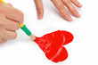 Female hand with brush paint draws the heart.