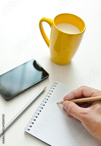 Photo: Writing notes or planning a schedule on blank spiral notebook Writing notes or planning a schedule on blank spiral notebook