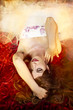 sensual woman with long red hair lying on a bed of flowers