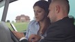 Young businesspeople work with tablet in car