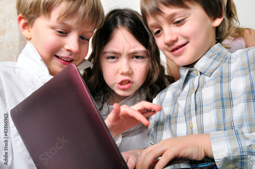 Photo: group of children friends playing studying at laptop group of children friends playing studying at laptop