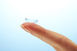 contact lens on finger on blue background