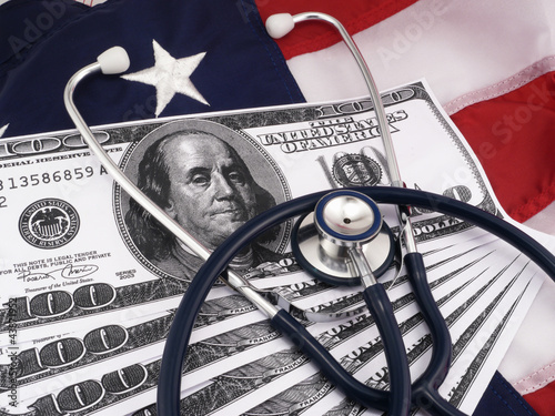 Photo: 100 Dollar Bills And Stethoscope Over American Flag 100 Dollar Bills And Stethoscope Over American Flag