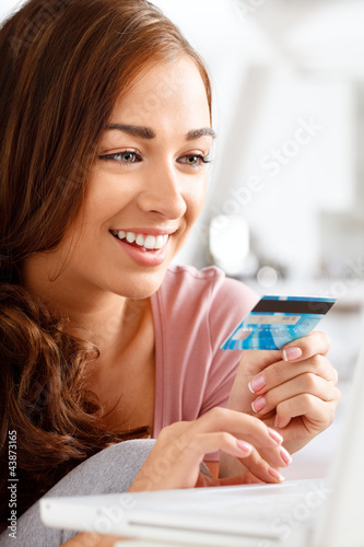 Foto: joyful young teenager shopping online with a credit card and lap joyful young teenager shopping online with a credit card and lap