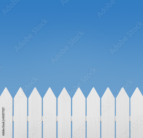Photo: White wooden fence against the sky with copy space White wooden fence against the sky with copy space