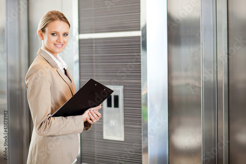 Photo: young businesswoman waiting for elevator in the building young businesswoman waiting for elevator in the building