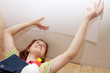 Woman glues ceiling tile