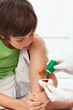 Boy receiving emergency treatment - disinfecting a wounded leg