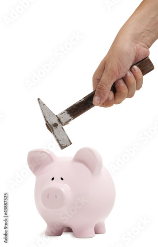 Photo: Male hand breaking a piggy bank Male hand breaking a piggy bank
