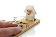 Hand of man caught in mousetrap set by the bank