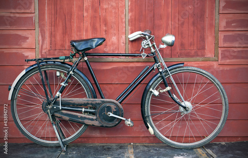 Photo: Vintage Bicycle standing near a vintage wood wall Vintage Bicycle standing near a vintage wood wall