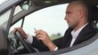 Young businessman smoking cigarettes in car