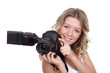 Cheerful woman shooting with a camera against white background