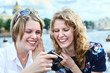 Photo: Two cheerful beauty women looking at screen of simple camera Two cheerful beauty women looking at screen of simple camera