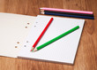 pencils and notebook on wooden table