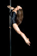 Young sexy woman exercise pole dance against a black background