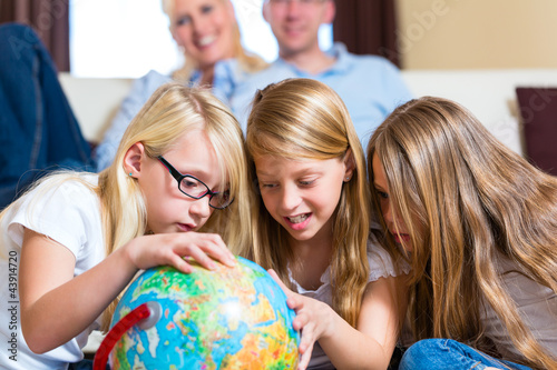 Foto: Family at home, the children playing with a globe Family at home, the children playing with a globe