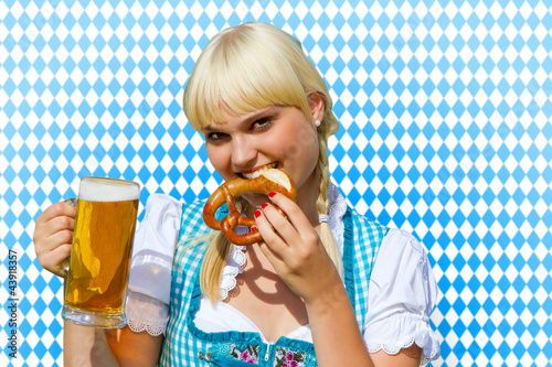 Foto: Junge Frau im Dirndl mit Bierkrug und Brezel Junge Frau im Dirndl mit Bierkrug und Brezel