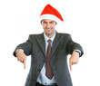 Photo: Smiling businessman in Santa's hat pointing down Smiling businessman in Santa's hat pointing down