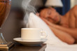 man sleeping on abed, a cup of hot tea