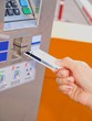 Person inserting a card into a vending machine